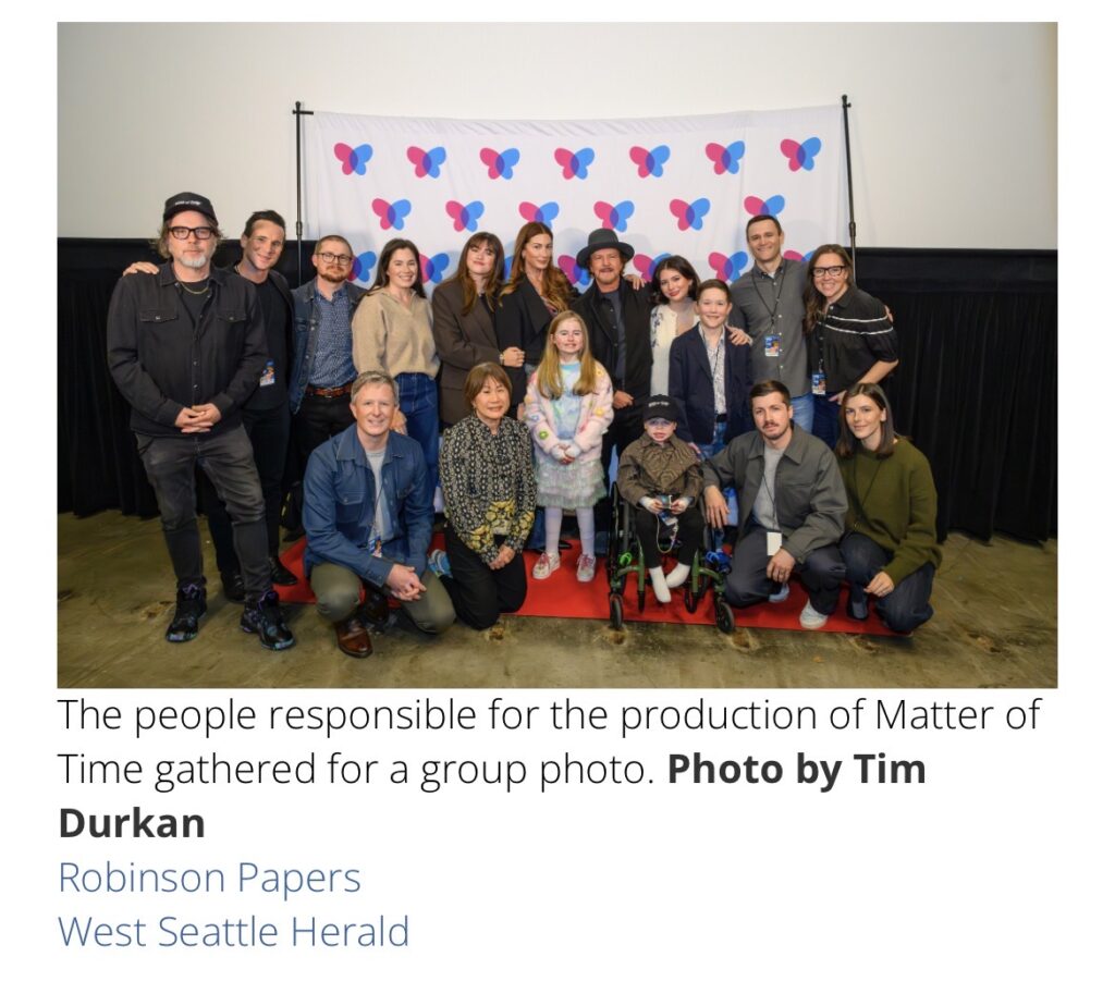 Group photo of the cast, families, and creators of the film Matter of Time standing together in front of a butterfly backdrop.